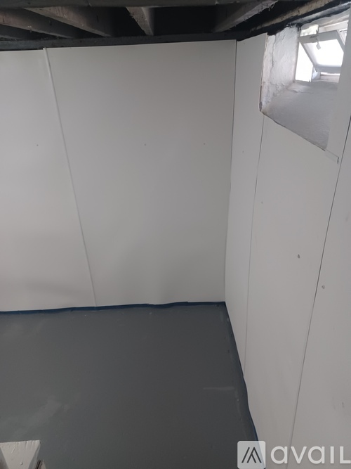 A room with white walls and a grey floor.