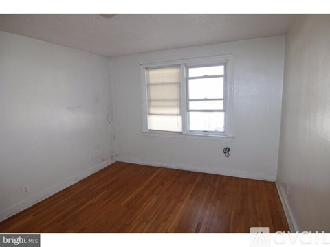 A room with a window and wooden floors.