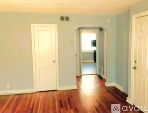 A room with a wooden floor and two white doors.
