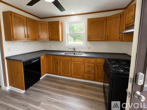 A kitchen with wooden cabinets and a black stove top.