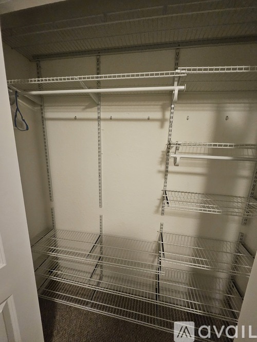 Empty white shelving unit with metal bars.