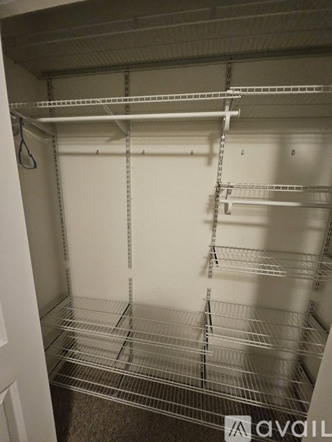 Empty white shelving unit with metal bars.