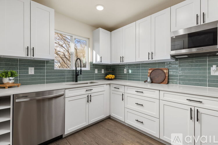 A kitchen with white cabinets and a stainless steel dishwasher.