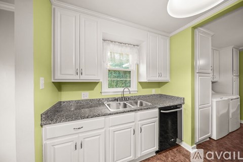 A kitchen with white cabinets and a granite countertop.