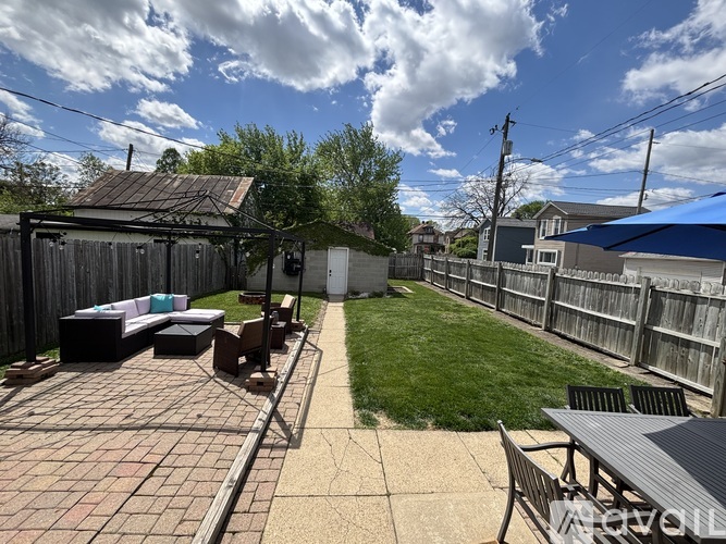 A backyard with a patio and a small building.