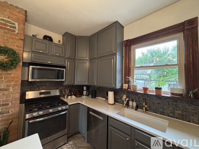 A kitchen with a brick wall and a stove top oven.