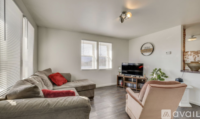 A living room with a couch, chair, and television.