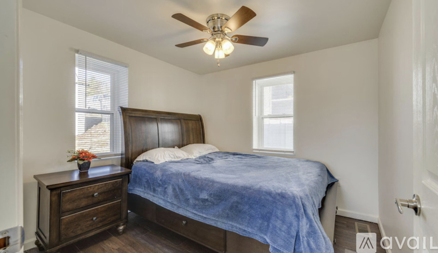 A bedroom with a bed, dresser, and window.