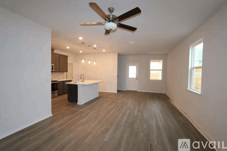 A spacious room with a ceiling fan and wooden flooring.