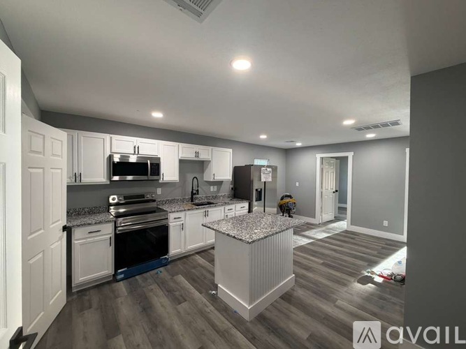 A modern kitchen with a granite countertop and stainless steel appliances.