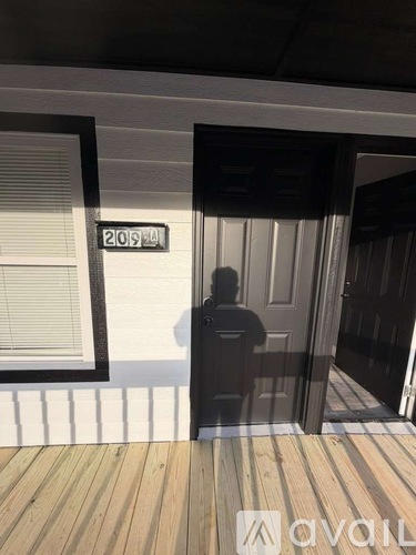 A person is standing in front of a door with a number 2051 on it.