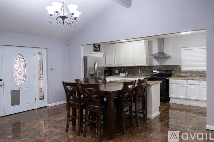 A kitchen with a table and chairs in the middle of the room.