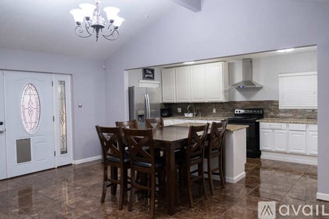 A kitchen with a table and chairs in the middle of the room.