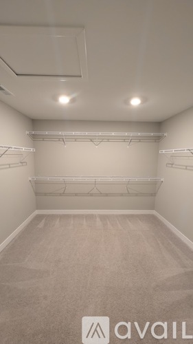 A sparsely furnished room with a carpeted floor and white walls.