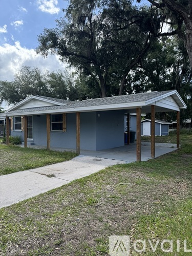 A house under construction with a grey roof and wooden pillars.