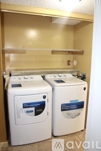 Two front loading washing machines in a small laundry room.