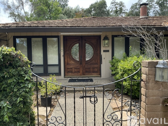A house with a brown door and a metal fence.