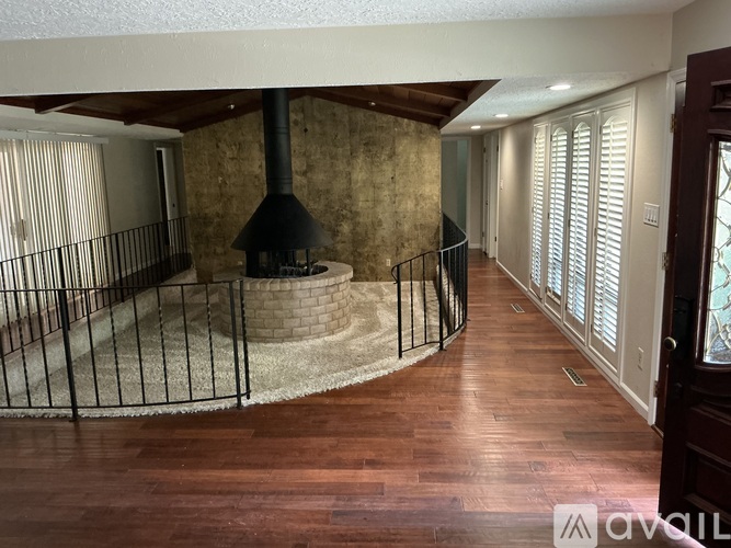 A living room with a wood burning stove and a railing.