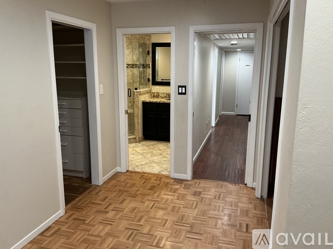 A hallway with a marble fireplace and a mirror above it.