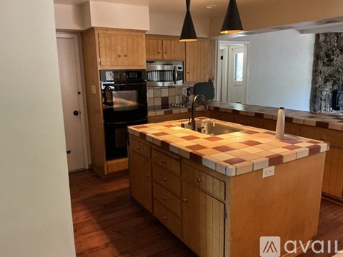 A kitchen with wooden cabinets and a checkered countertop.