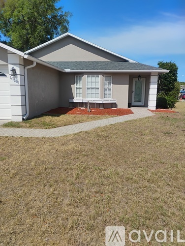 A house with a grey roof and a white door is for sale.