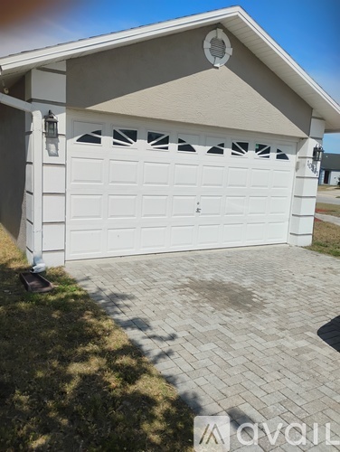 A white garage door with a decorative black pattern on the top.