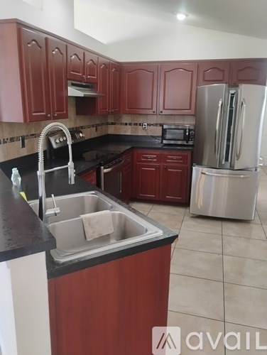 A kitchen with brown cabinets and a black countertop.