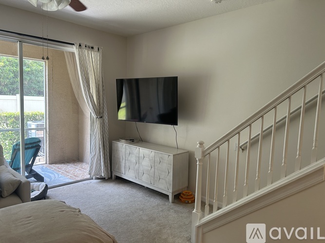 A living room with a television and a staircase.