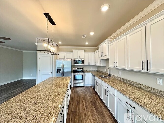 A kitchen with a granite countertop and stainless steel appliances.