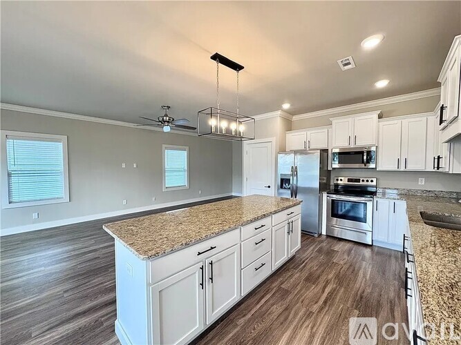 A kitchen with white cabinets and a granite countertop.