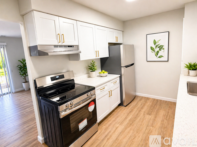 A modern kitchen with a black stove top oven and white cabinets.