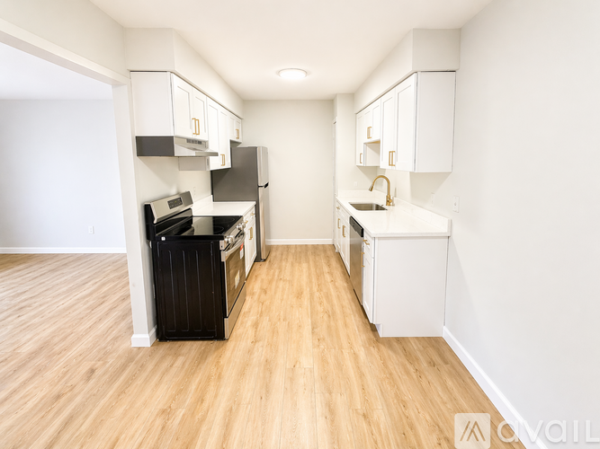 A kitchen with white cabinets and a black fridge.