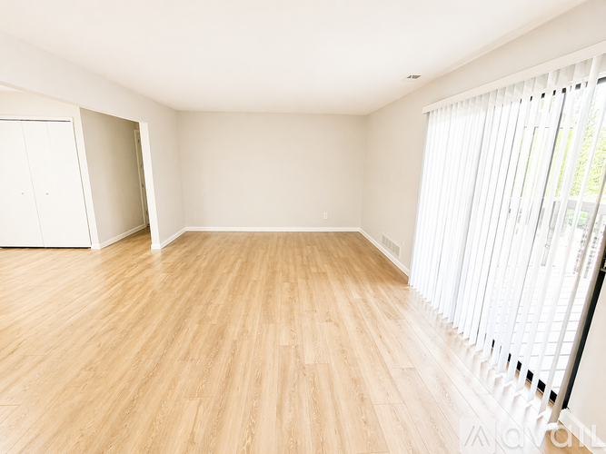 A room with wooden flooring and white walls.
