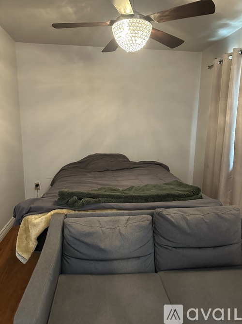 A bedroom with a bed and a ceiling fan.