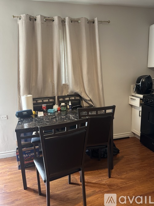 A kitchen with a black table and chairs.