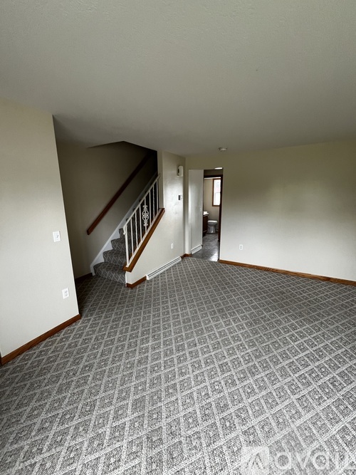 A hallway with a tiled floor and a staircase.