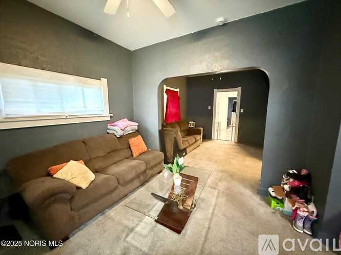 A living room with a brown couch and a coffee table.