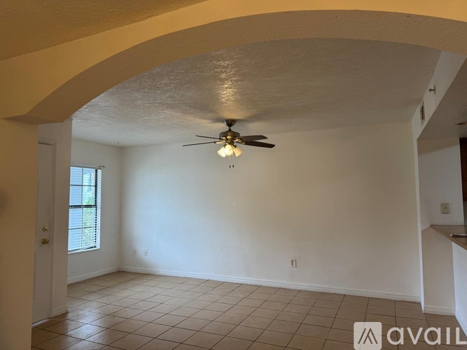 A room with a ceiling fan and tiled floor.