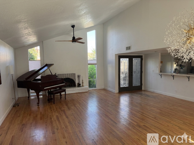 A room with a piano and a chandelier.