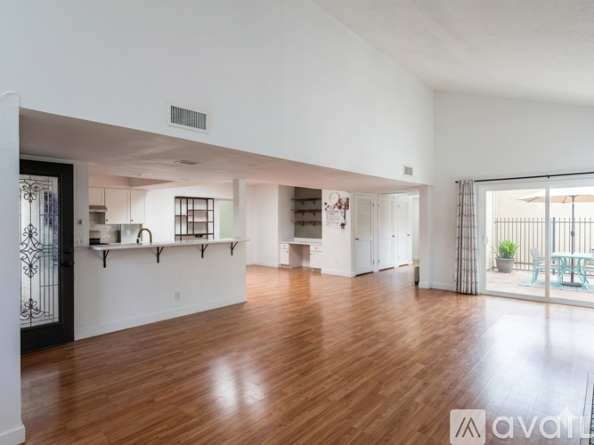 A spacious room with wooden floors and white walls.