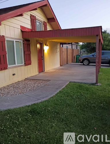 A house with a red awning and a car parked in the driveway.