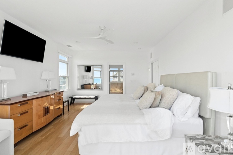 A bedroom with a large bed and a television mounted on the wall.