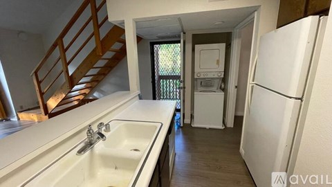 A kitchen with a sink and a refrigerator.
