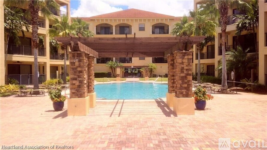 A pool area with a stone archway and palm trees.