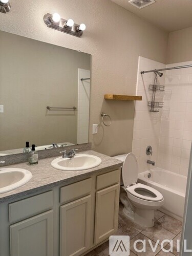 A bathroom with a toilet, sink, and mirror.