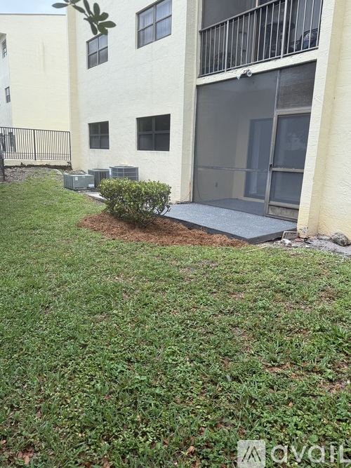 A small bush is in front of a building.