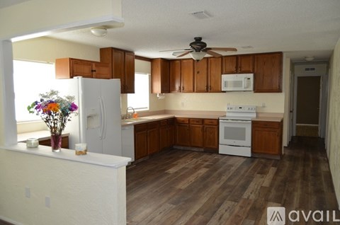 A kitchen with wooden floors and white appliances.