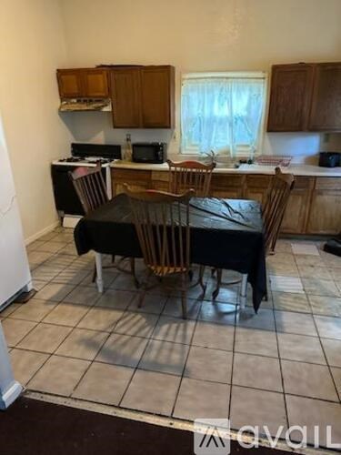 A kitchen with a table and chairs in the middle.
