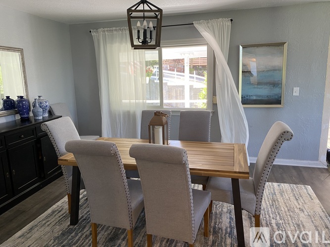 A dining room with a wooden table and chairs.