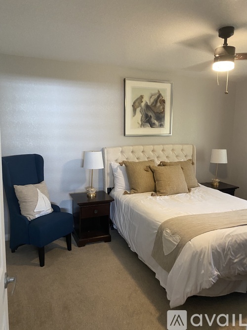 A bedroom with a large bed and a blue chair.